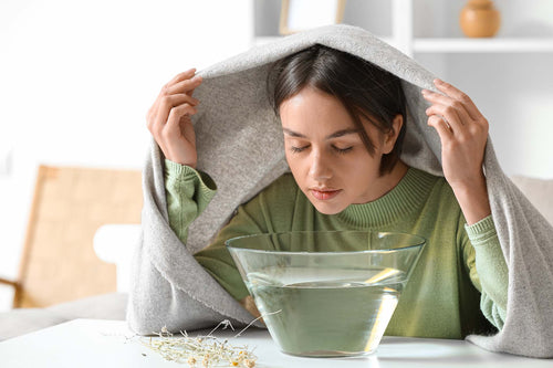 a woman unstuffing her clogged nose through steam inhalation